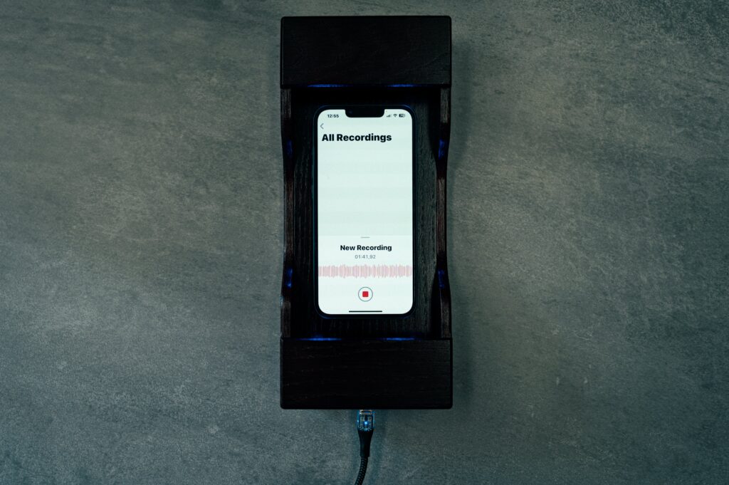 ASU 1.0 Acoustic Safe Stand, a security device that blocks mobile phone recordings with ultrasonic noise, ensuring privacy without disrupting phone connectivity.